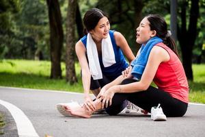 Aziatisch vrouw is krijgen enkel letsel terwijl oefening in de park. foto