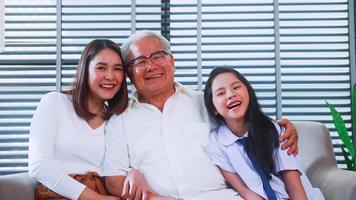 gelukkig familie met opa, moeder en weinig dochter uitgeven tijd samen in leven kamer. foto