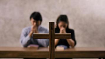 een jong Aziatisch christen paar bidden naar Jezus Christus in een kerk. foto