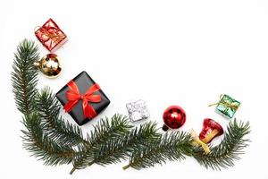 top visie van Kerstmis geschenk doos rood ballen met net takken, pijnboom kegels, rood bessen en klok Aan wit achtergrond. foto