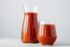 rode tomatensap in glas geïsoleerd op witte achtergrond. groentesmoothie. biologische drank. horizontaal schot. gezonde gevitamineerde drank foto