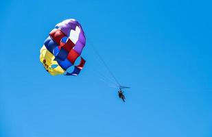 parachute en toeristen in de blauw lucht foto