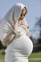 gelukkig jong zwanger vrouw buitenshuis foto