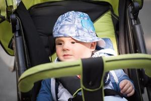 baby jongen zittend in de kinderwagen foto