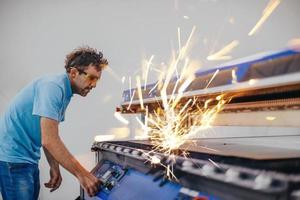 binnen zwaar industrie. een Mens werken in een modern fabriek Aan een cnc machine. selectief focus foto