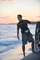 portret van een jong kitsurfen Mens Bij strand Aan zonsondergang foto