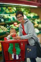 moeder met baby in boodschappen doen foto