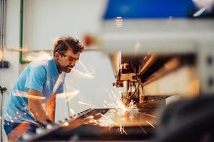 binnen zwaar industrie. een Mens werken in een modern fabriek Aan een cnc machine. selectief focus foto