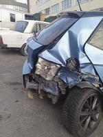 achterzijde visie van een crashte blauw hatchback auto Bij straat foto