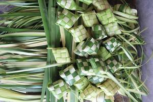 ketupat of rijst- knoedels. ketupat is een natuurlijk rijst- mouw gemaakt van jong kokosnoot bladeren naar koken rijst- welke is altijd beschikbaar gedurende Islamitisch vakantie foto