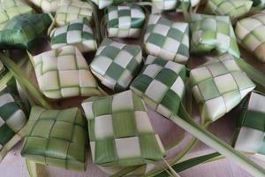 ketupat of rijst- knoedels. ketupat is een natuurlijk rijst- mouw gemaakt van jong kokosnoot bladeren naar koken rijst- welke is altijd beschikbaar gedurende Islamitisch vakantie foto