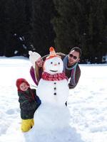 gelukkige familie sneeuwpop maken foto