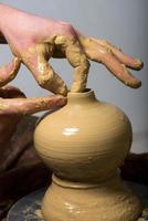 handen van een pottenbakker, waardoor een aarden pot ontstaat