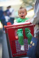 moeder met baby in boodschappen doen foto