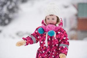 weinig meisje hebben pret Bij besneeuwd winter dag foto