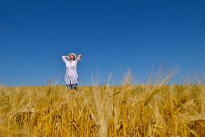 jonge vrouw in tarweveld in de zomer foto