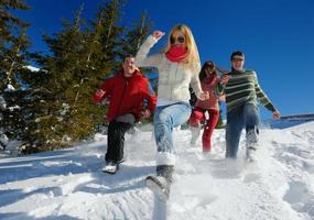 vrienden hebben pret Bij winter Aan vers sneeuw foto