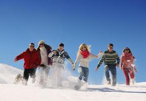 vrienden hebben pret Bij winter Aan vers sneeuw foto