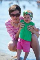 mama en baby op het strand veel plezier foto