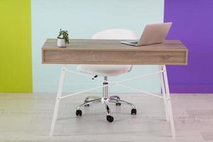 huis kantoor concept. stoel, laptop, bureau en bloemen. foto