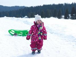 weinig baby meisje hebben pret Aan vers sneeuw foto