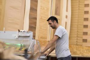 arbeider in een fabriek van houten meubelen foto