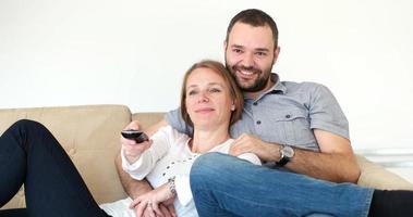senior paar aan het kijken TV in modern villa foto