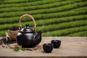 kop van heet thee met theepot, groen thee bladeren en droog kruiden Aan de houten tafel in plantages achtergrond met leeg ruimte, biologisch Product van de natuur voor gezond met traditioneel foto