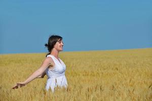 jonge vrouw in tarweveld in de zomer foto