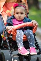 baby meisje zittend in de kinderwagen foto