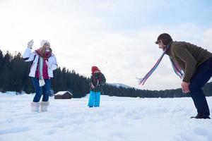 gelukkig familie spelen samen in sneeuw Bij winter foto