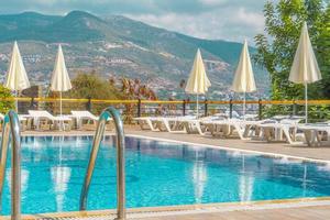 luxueus zwembad in de tuin van een privaat villa, hangende stoel met kussens voor vrije tijd toeristen, in zomer foto