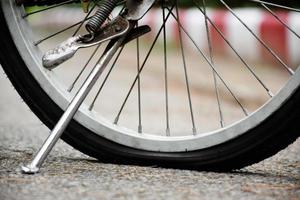 detailopname achterzijde vlak wiel van wijnoogst fiets Aan bestrating in de avond van de dag, zonsondergang licht bewerkt, zacht en selectief focus foto