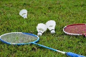 badminton racket en badminton shuttle tegen bewolkt en blauwe lucht achtergrond, buitenshuis badminton spelen concept. selectief focus Aan racket. foto