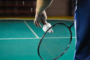 binnen- badminton spelen door portie shuttles rackets. buitenshuis badminton spelen concept. foto