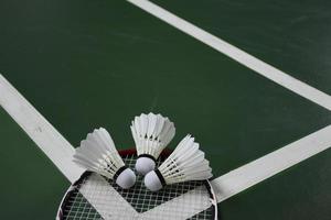 room wit badminton shuttles en rackets Aan groen verdieping in binnen- badminton rechtbank foto