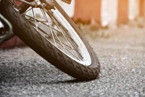 detailopname visie van achterzijde vlak band van wijnoogst fiets welke geparkeerd Aan bestrating naast de weg. zacht en selectief focus. foto