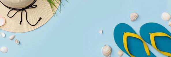 reizigers accessoires met slippers, hoed en schaaldieren geïsoleerd blauw achtergrond, overhead visie met kopiëren ruimte, tropisch reizen concept foto