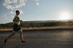 triatlonatleet die op ochtendtraining loopt foto