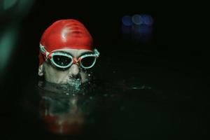 authentiek triatleet zwemmer hebben een breken gedurende moeilijk opleiding Aan nacht neon gel licht foto