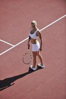 jonge vrouw speelt tennis foto
