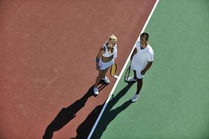 gelukkig jong paar Speel tennis spel buitenshuis foto