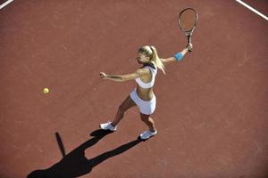 jonge vrouw tennissen buiten foto