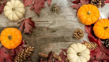 feestelijk herfstdecor van pompoenen, dennen en bladeren op een houten ondergrond. concept van thanksgiving day of halloween. plat lag herfstcompositie met kopieerruimte. foto
