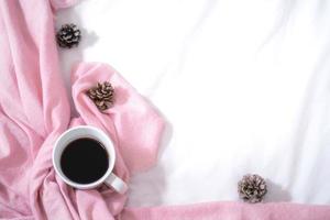 Kerstmis samenstelling. kop van koffie, sjaal Aan roze achtergrond. kerstmis, winter concept. vlak leggen, top visie, kopiëren ruimte foto