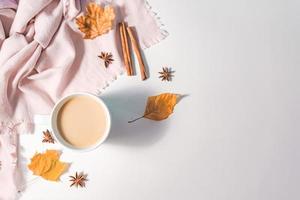 herfst of winter concept met pijnboom en esdoorn- bladeren, koffie kop , kaneel, en sjaal, vlak leggen, top visie. foto