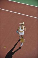 jonge vrouw speelt tennis foto