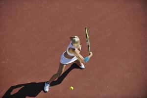 jonge vrouw tennissen buiten foto