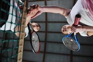 jong meisjes spelen tennis spel binnen- foto