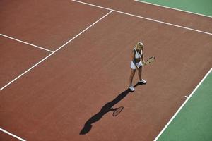 jonge vrouw tennissen buiten foto